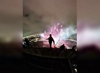 A Polish climber on the roof of a 215-meter tower for the Rotterdam fireworks display