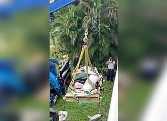 Un homme obèse soulevé par une grue pour recevoir des soins médicaux