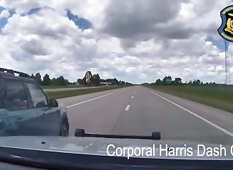 The dashcam shows the bullet passing through the window just a few inches from the police officer