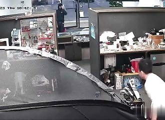 A shopkeeper defends his business against two thieves