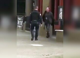 A policeman immediately calms an aggressive homeless woman