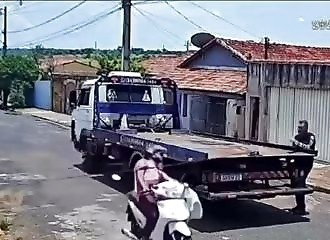 This scooterist narrowly escapes decapitation by running into a cable stretched out in the middle of the road