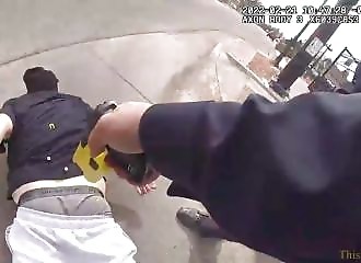 A policeman tases her as she lies on the ground