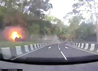 A motorist takes a bend a little too fast, his car flies off the road and catches fire