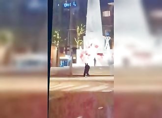 They calmly spray-paint the National Monument in Amsterdam red as passersby look on