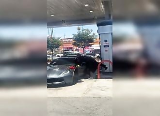 Two police officers struggle to subdue a shirtless driver in a Corvette