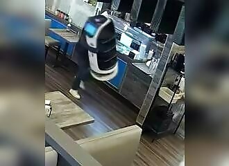 A degenerate tries to steal a food delivery robot from a restaurant